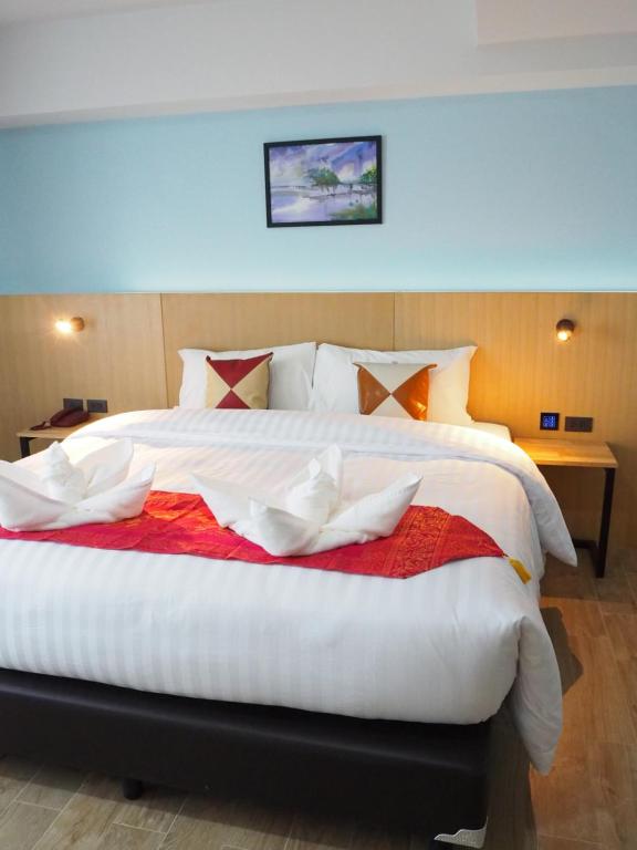 - une chambre avec un grand lit blanc et une couverture rouge dans l'établissement Samui City Hotel, à Chaweng