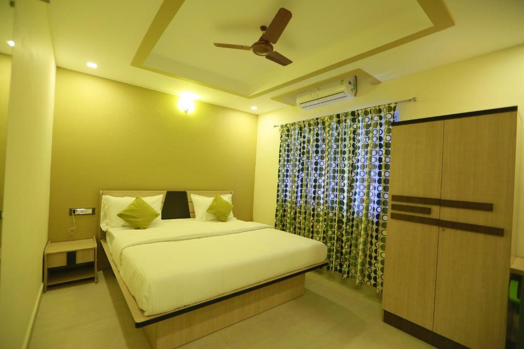 een slaapkamer met een bed en een plafondventilator bij Kans One in Chennai