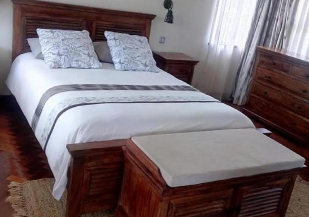 a bedroom with a large bed with white sheets at ACK St.Julians Centre in Limuru