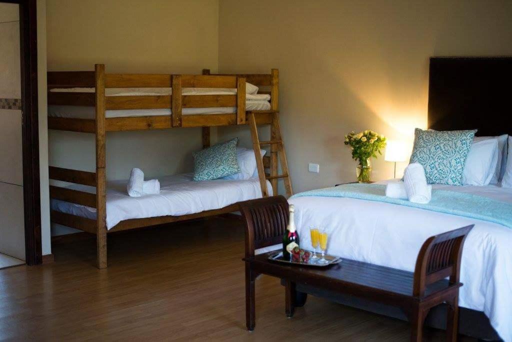 een slaapkamer met 2 stapelbedden en een tafel bij The Graaff-Reinet Suites in Graaff-Reinet