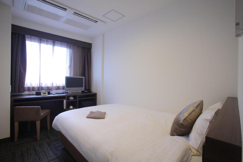 Postel nebo postele na pokoji v ubytování Shimizu City Hotel