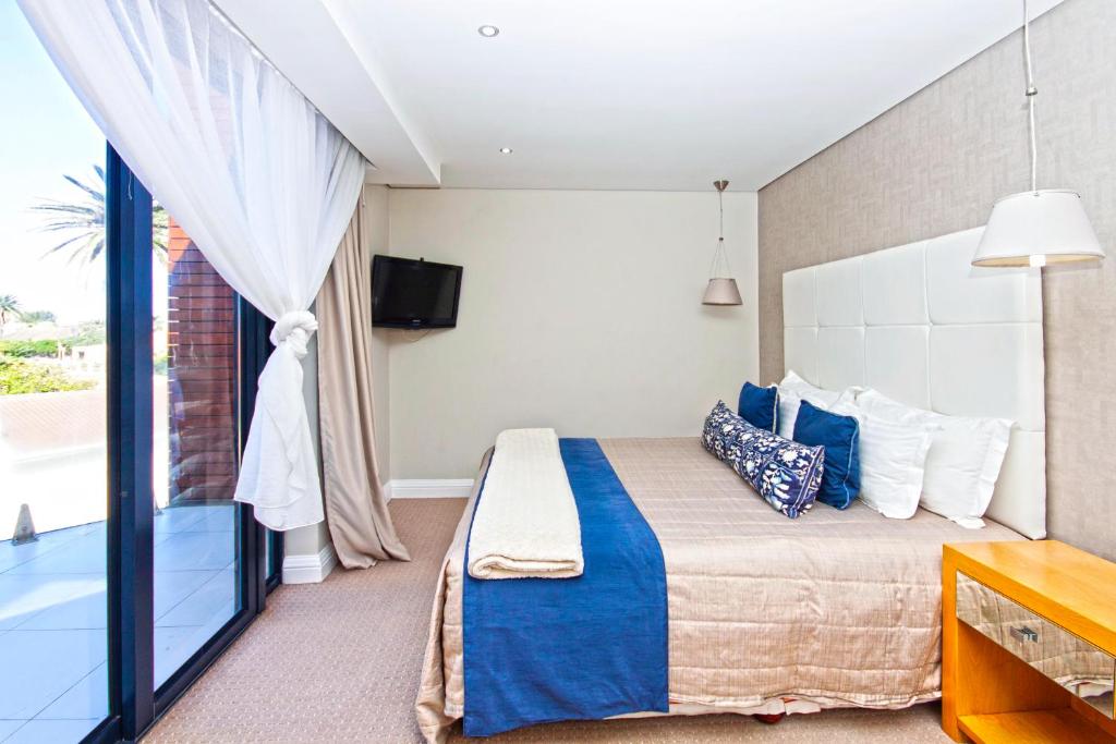 a bedroom with a bed and a large window at Isango Gate in Port Elizabeth