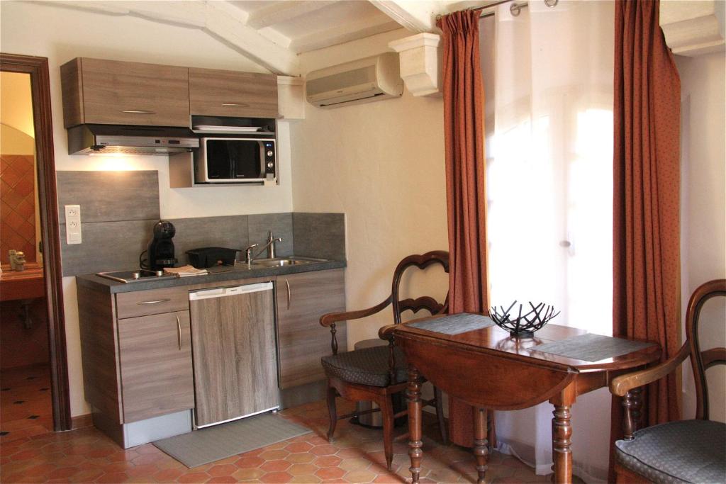 a kitchen with a table and a sink and a table and chairs at Les Bastidieres - Cap Brun in Toulon