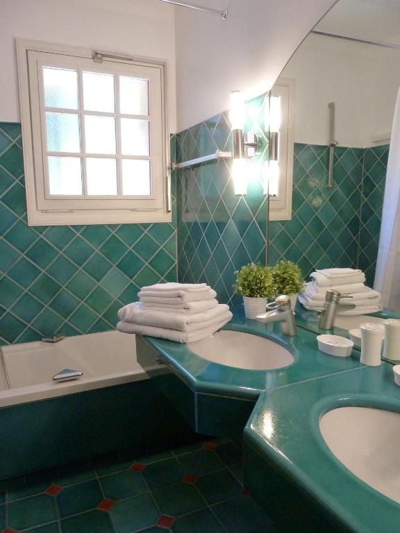 a green bathroom with a sink and a mirror at Les Bastidieres - Cap Brun in Toulon