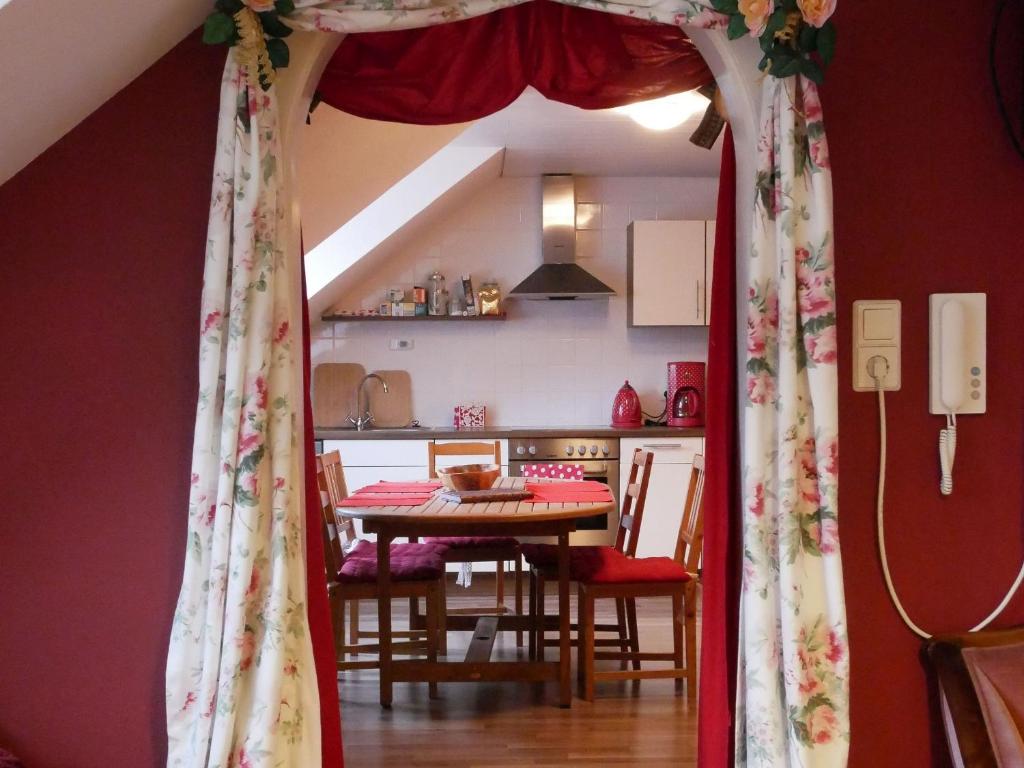 Zimmer mit einem Tisch und einem roten Vorhang in der Unterkunft Ferienwohnung Comic Fantasy in Lindau