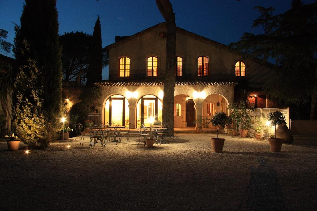 a lit up building with tables and chairs at night at Les Bastidieres - Cap Brun in Toulon