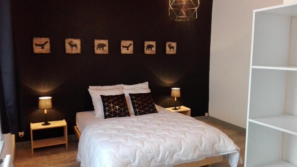 a bedroom with a white bed with black walls at La bressaude - vacances-en-vosges - ménage compris in La Bresse