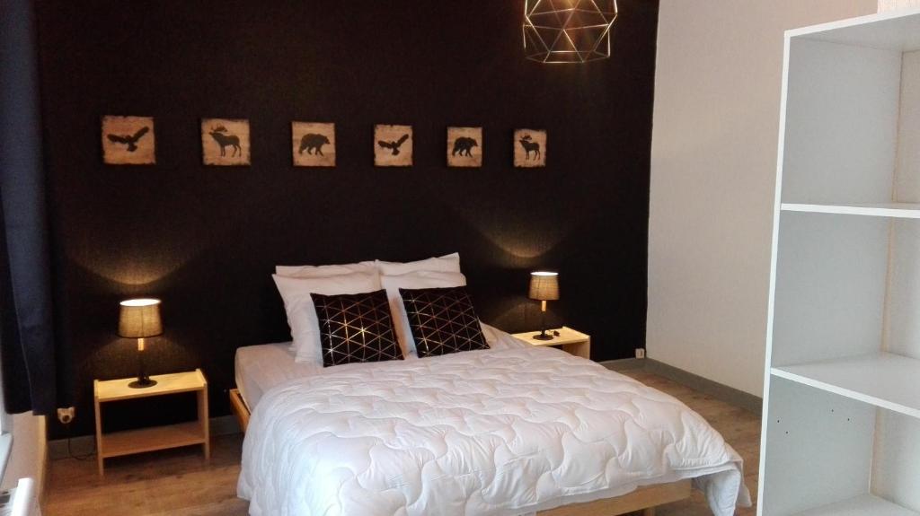 ラ・ブレスにあるLa bressaude - vacances-en-vosgesの黒い壁の白いベッドが備わるベッドルーム1室