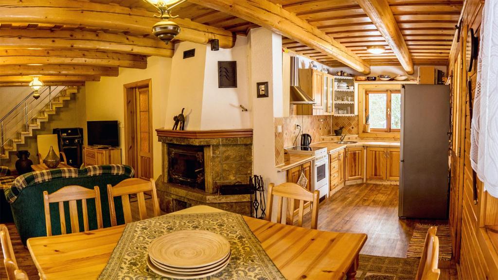 a kitchen and dining room with a table and a fireplace at Chata Delta in Liptovský Mikuláš