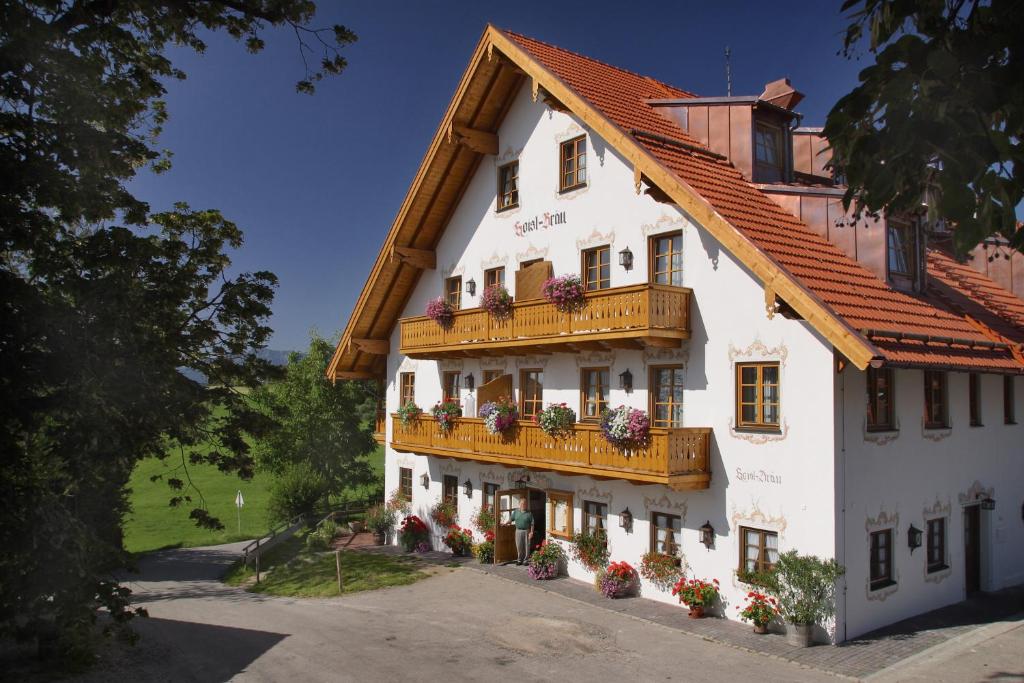 un edificio blanco con balcón y flores. en Landhotel Hoisl-Bräu, en Penzberg