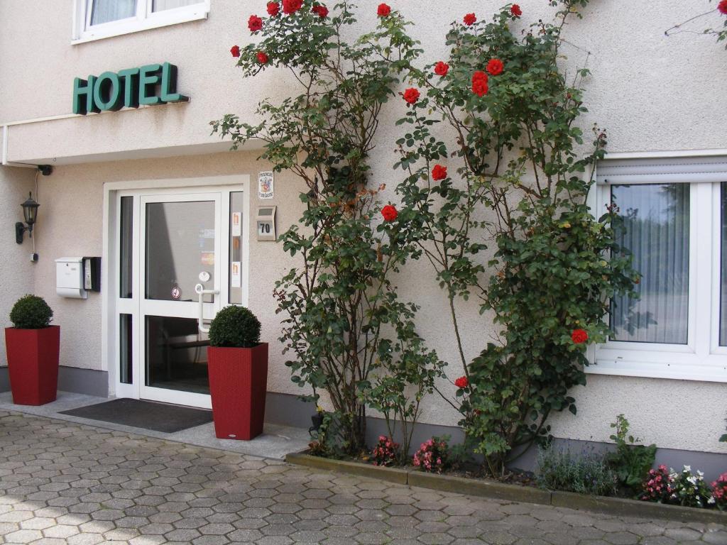 ein Gebäude mit roten Blumen vor einer Tür in der Unterkunft Hotel Schmerkötter in Bochum