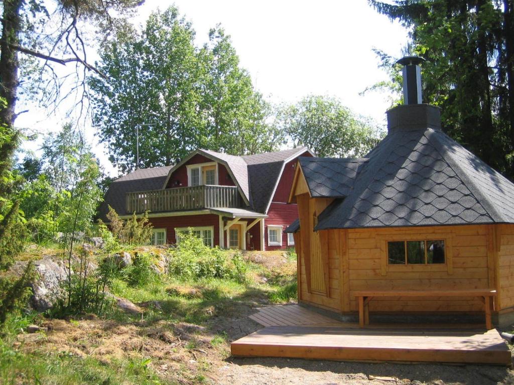 a small wooden house in front of a house at Mäkelän Lomatuvat Bed and Breakfast in Hyytiälä