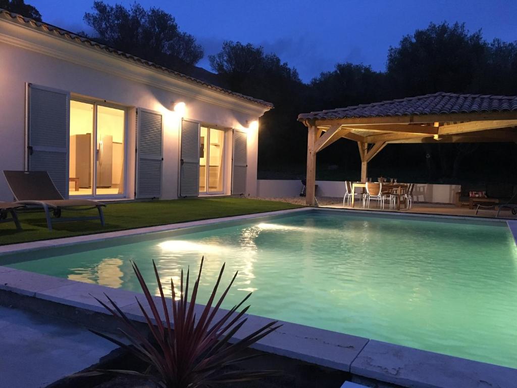 a swimming pool in front of a house at night at Domaine Vermentinu in Patrimonio