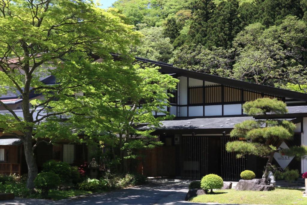 um edifício com uma árvore em frente em Itamuro Onsen Daikokuya em Nasushiobara