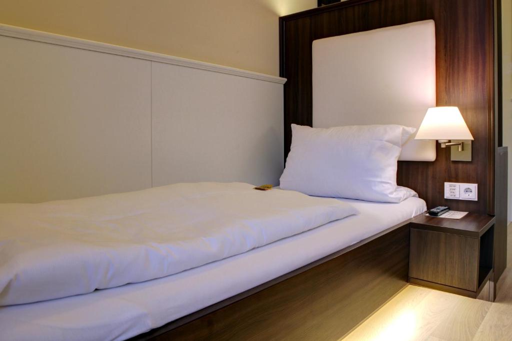Postel nebo postele na pokoji v ubytování The Heidelberg Exzellenz Hotel