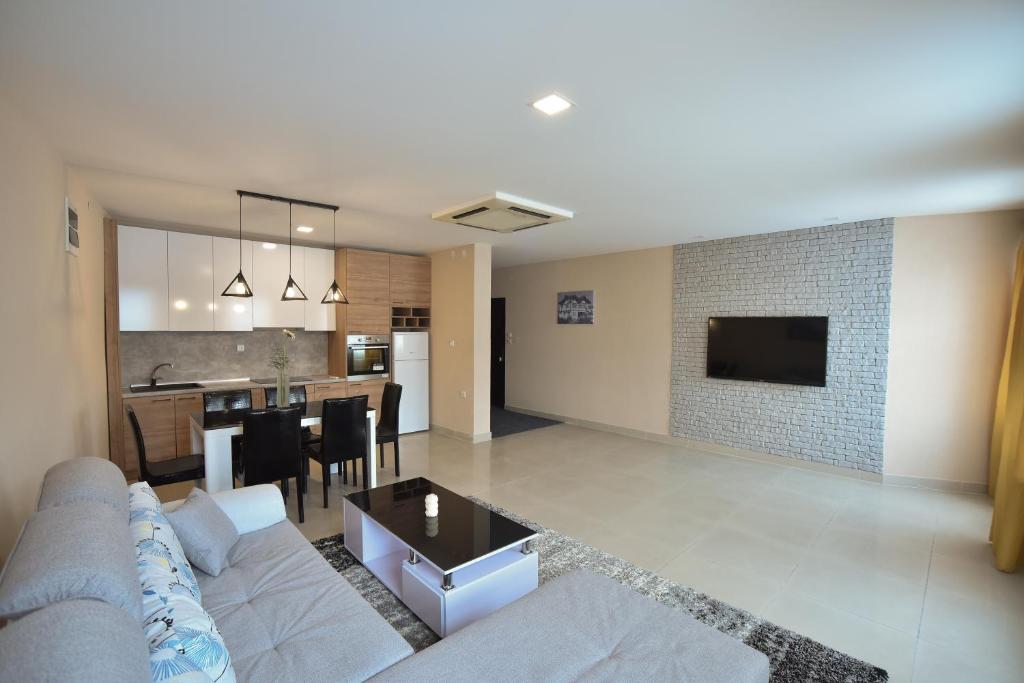 een woonkamer en een keuken met een bank en een tafel bij City Center Apartments in Pirot