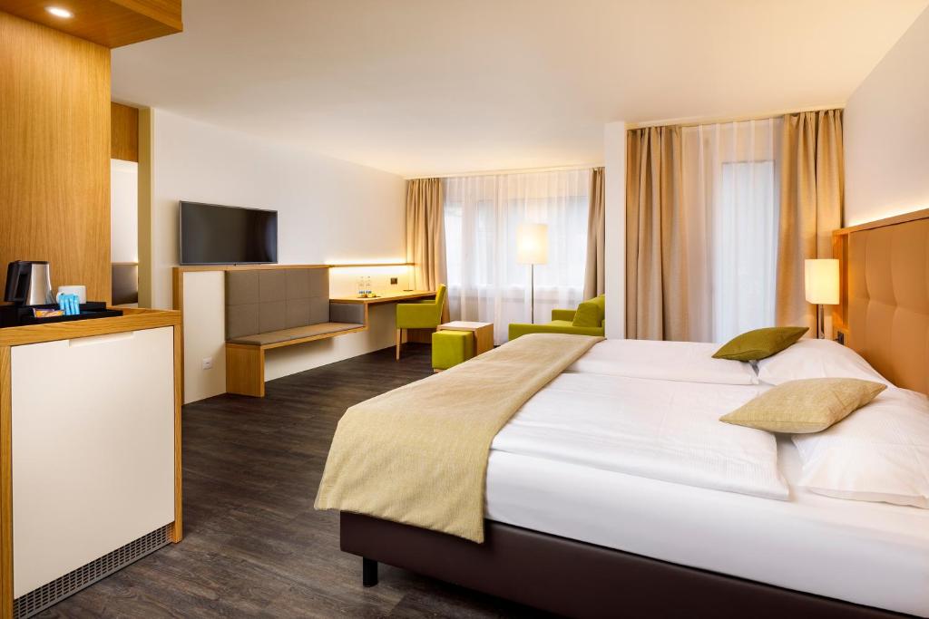 Postel nebo postele na pokoji v ubytování Ramada by Wyndham Baden Hotel du Parc