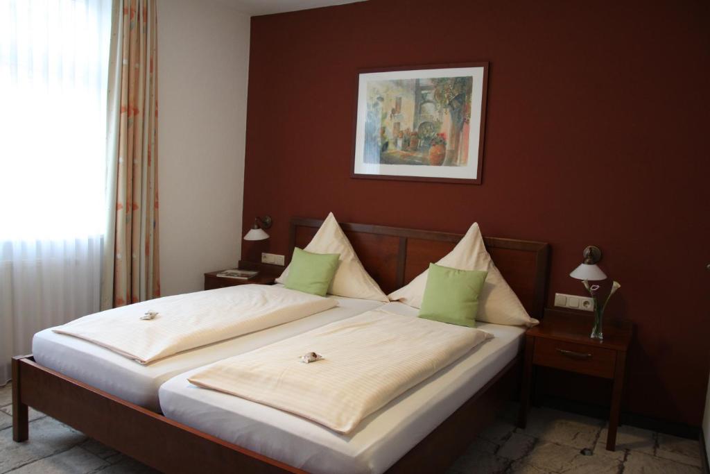 a bedroom with a large bed with green pillows at Hotel-Restaurant 1735 in Speyer