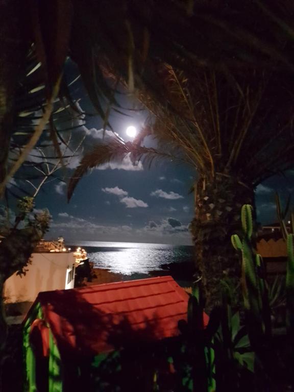 una vista de la playa por la noche con la luna en Vivienda Vacacional Monteprimero 2, en Tamaduste
