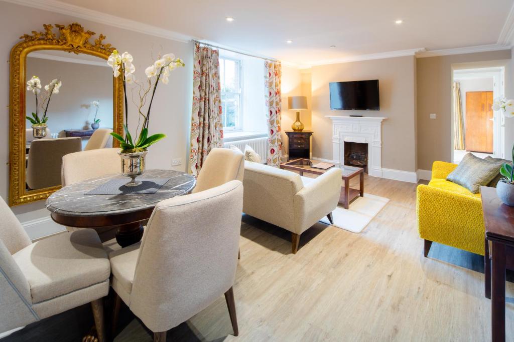 a living room with a table and chairs and a mirror at Beech House in Bristol