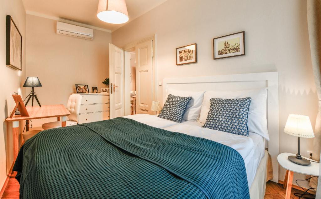 Un dormitorio con una cama con un edredón verde y blanco. en Apartments Rybná, en Praga