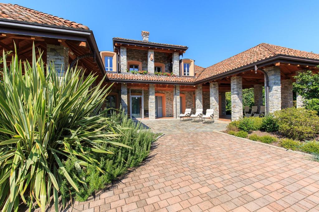 une maison avec une allée en briques devant elle dans l'établissement Villa Il Grotto, à Verbania