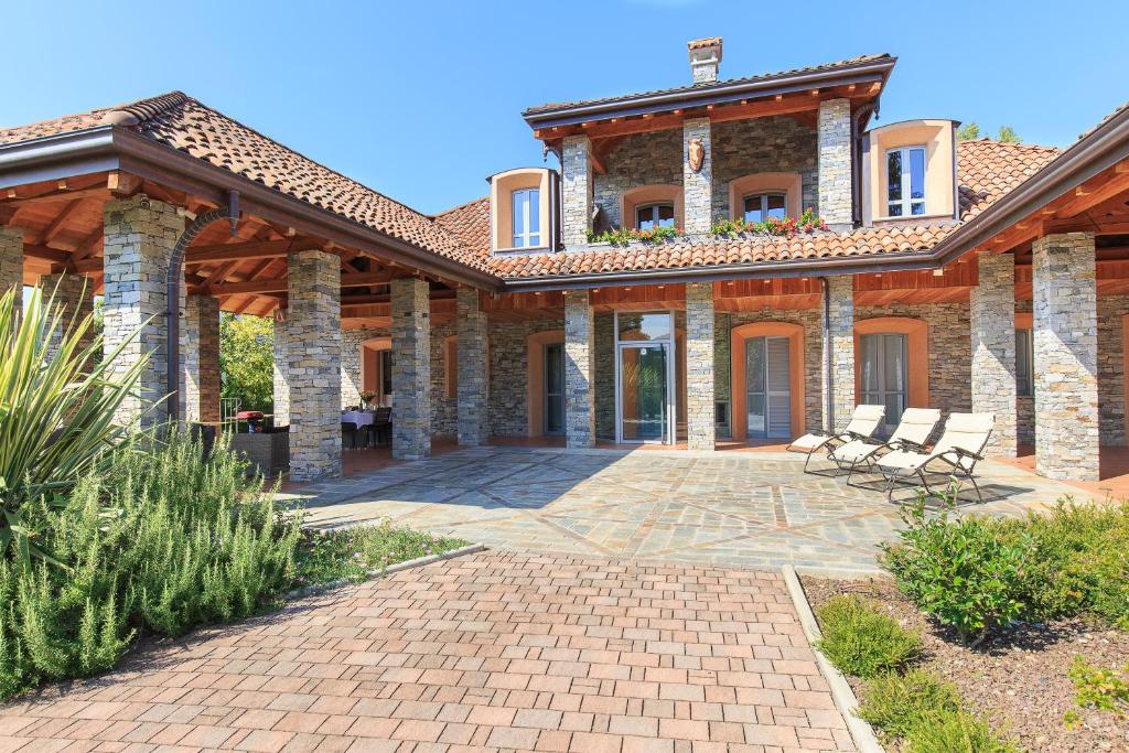 une grande maison en briques avec des chaises sur la terrasse dans l'établissement Villa Il Grotto, à Verbania 31 autres photos