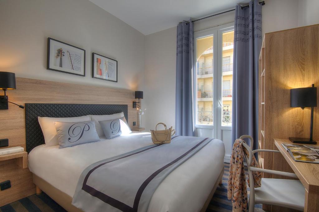 Un dormitorio con una cama grande y una ventana en Hotel Paganini en Niza