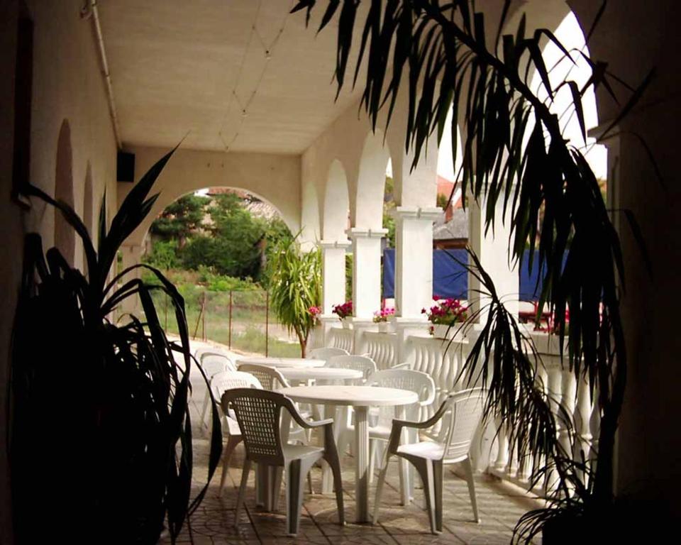 a group of white tables and chairs in a building at Penzion Gapa in Šahy