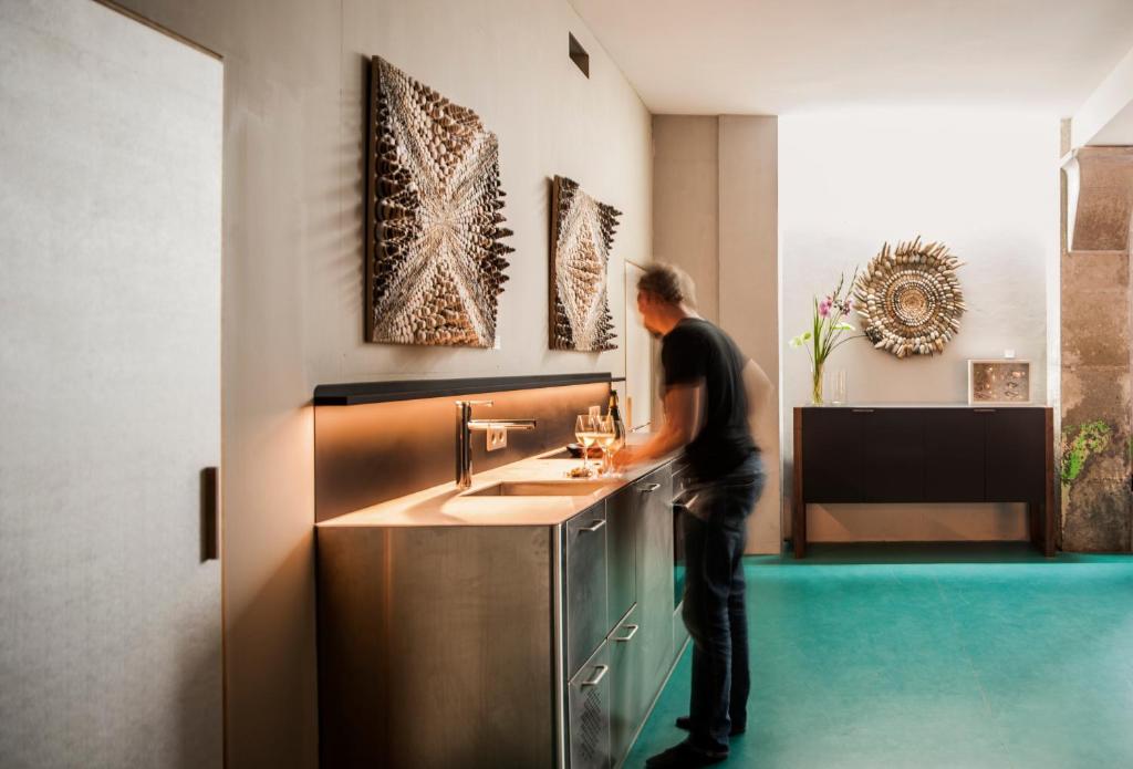 a man standing in a kitchen with a sink at himmel und himmel in Munich