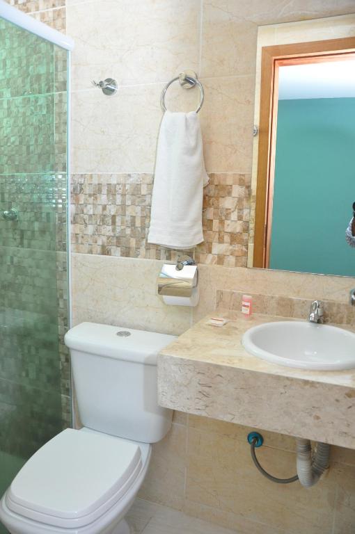 a bathroom with a toilet and a sink at Bonjour Hotel in Macaé