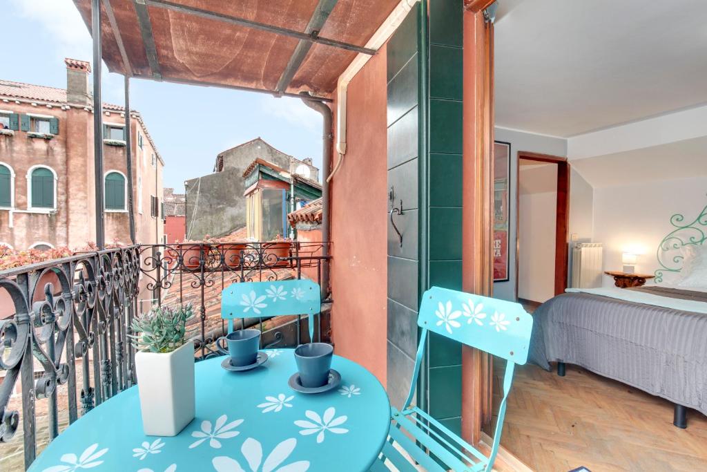Zimmer mit einem Balkon mit einem Bett und 2 Stühlen in der Unterkunft Via Garibaldi-Gigli Biennale Terrace in Venedig