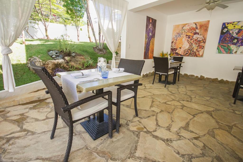 a dining room with a table and chairs on a stone floor at Casa Veintiuno in Sosúa