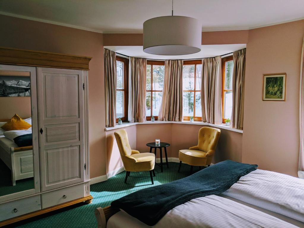 1 Schlafzimmer mit einem Bett, 2 Stühlen und einem Tisch in der Unterkunft Chalet Sonneck in Seefeld in Tirol