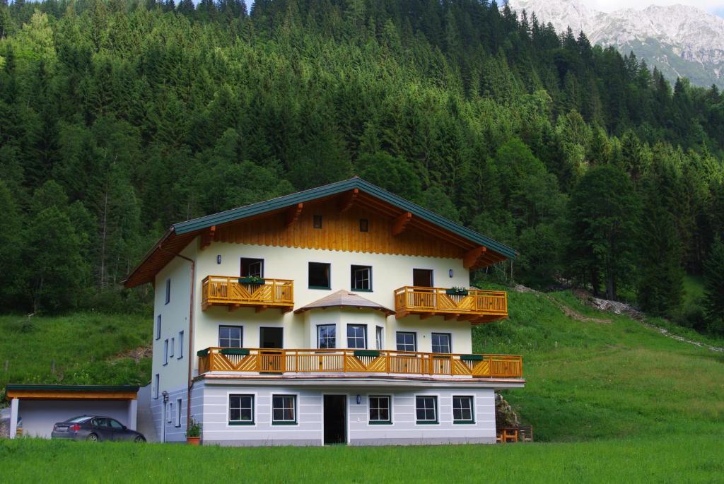 ein großes weißes Gebäude mit Holzbalkonen auf einem Hügel in der Unterkunft Appartement Tauernhof in Kleinarl