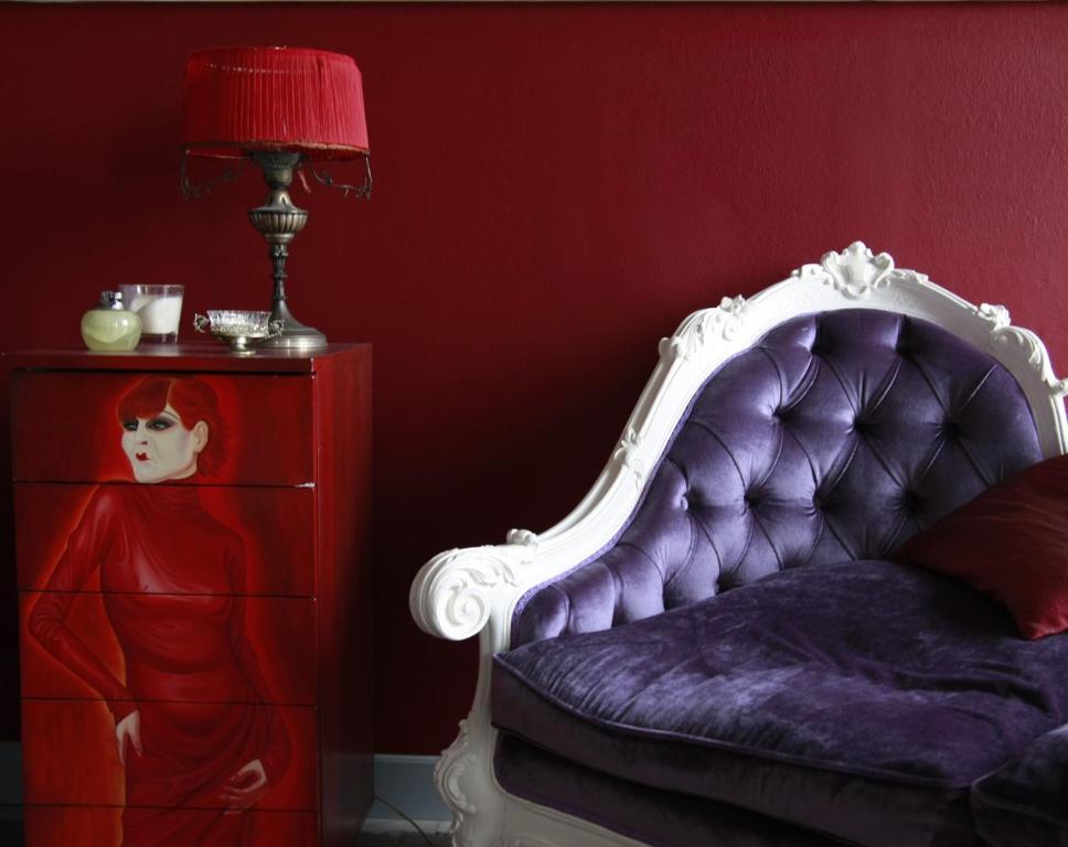 een slaapkamer met een paars bed met een lamp en een dressoir bij Maison Decò in Catania