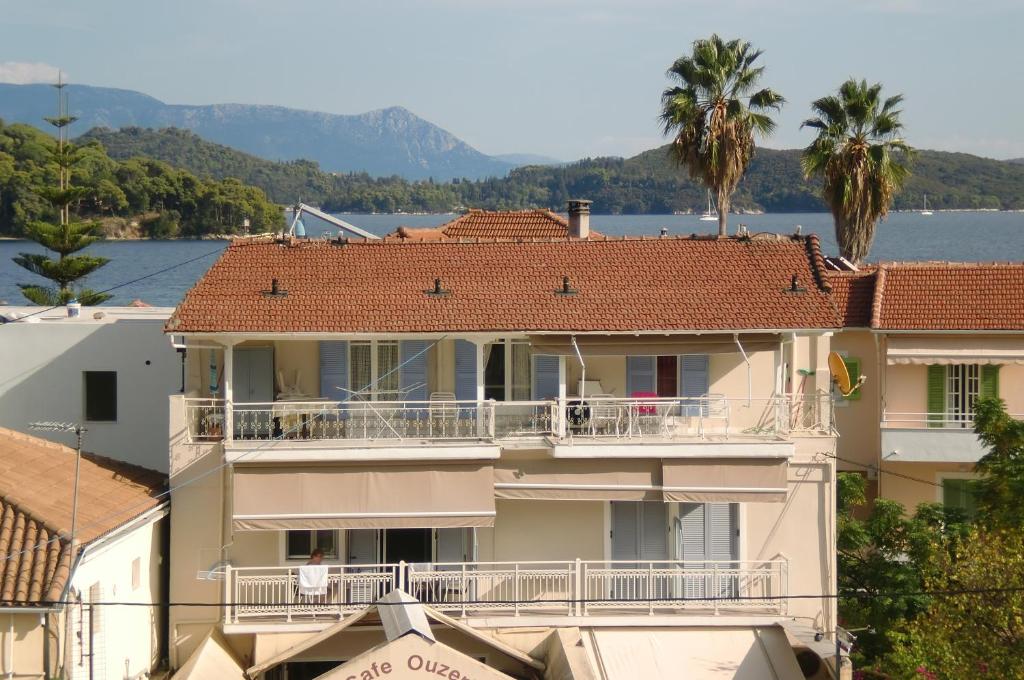 a large apartment building with a balcony and palm trees at Nidri Zone in Nydri