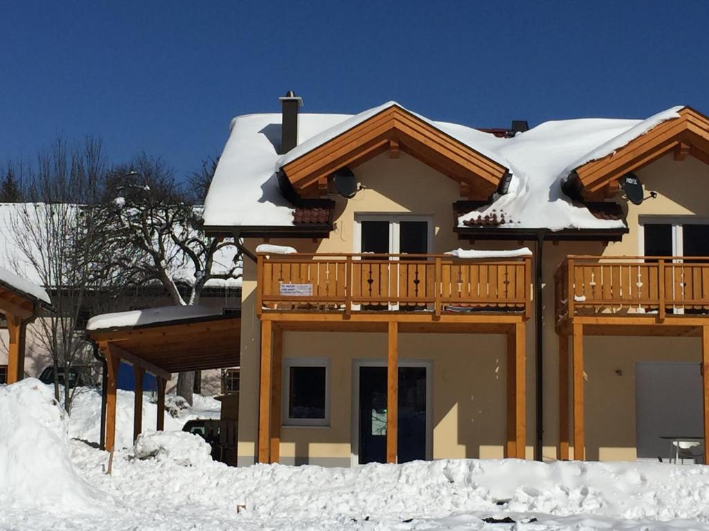 a house with snow on the roof at Berghaus Christel, bergbeek in grote tuin in Arnoldstein