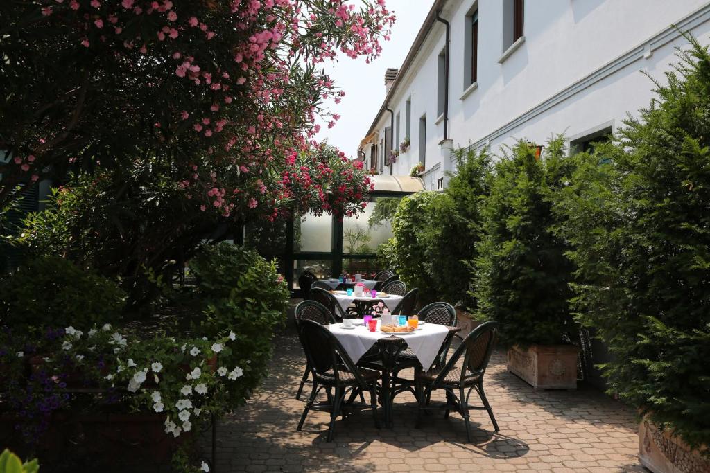 un tavolo e sedie in un giardino fiorito di Hotel Bed and Breakfast Il Granaio Mantova a Porto Mantovano