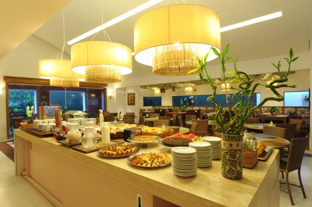 um buffet de pequeno-almoço num restaurante com pratos de comida em Portal Da Praia Hotel em Fortaleza