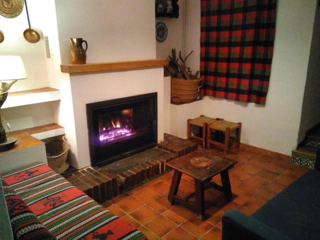 ein Wohnzimmer mit einem Kamin und einem Sofa in der Unterkunft La Casilla in María