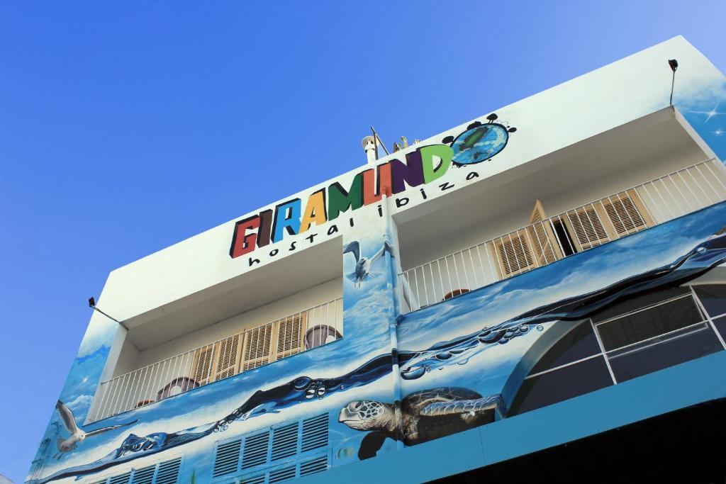 un edificio con un cartello sul lato di Hostal Giramundo a Ibiza Città