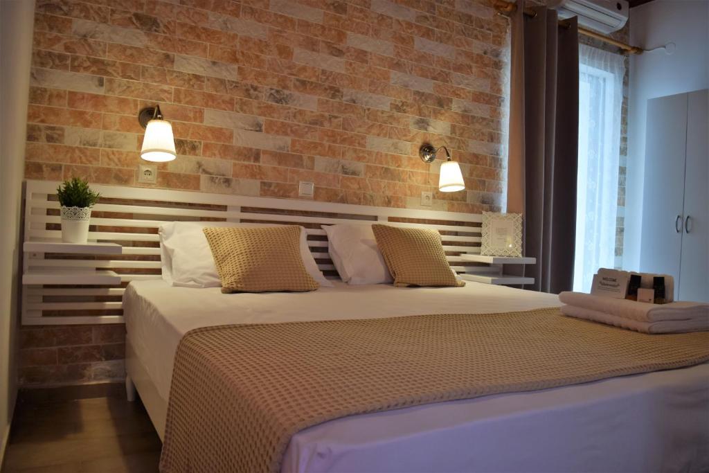 1 dormitorio con cama y pared de ladrillo en The Coast, en Anaxos