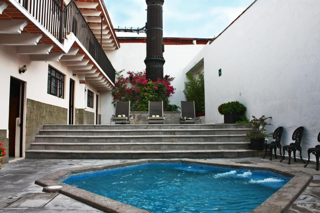 a swimming pool in the courtyard of a house at Casa Blanca Tequisquiapan in Tequisquiapan