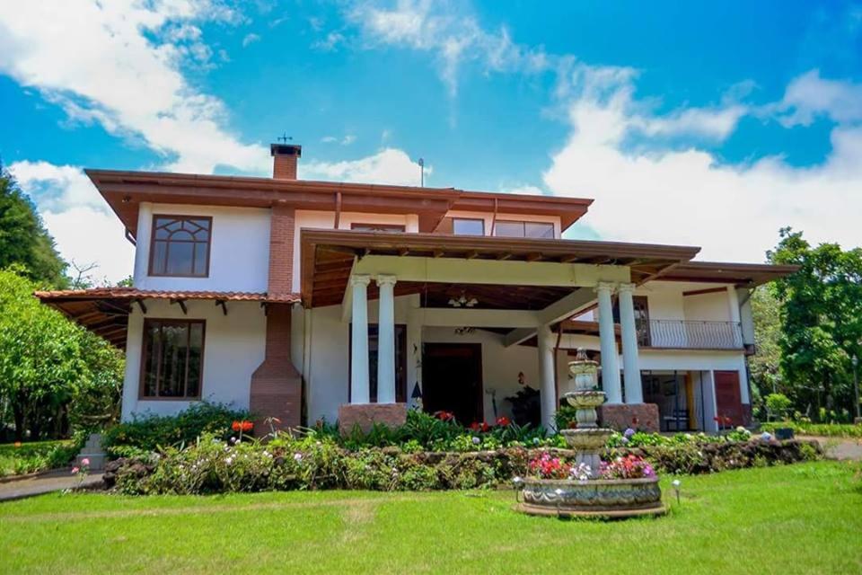 a house with a green lawn in front of it at Villa Ilusion in San Jerónimo
