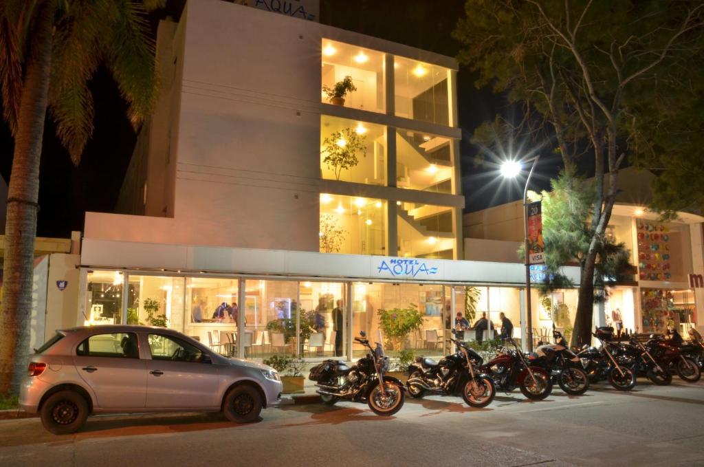 une voiture garée devant un immeuble avec des motos dans l'établissement Aqua Hotel, à Punta del Este