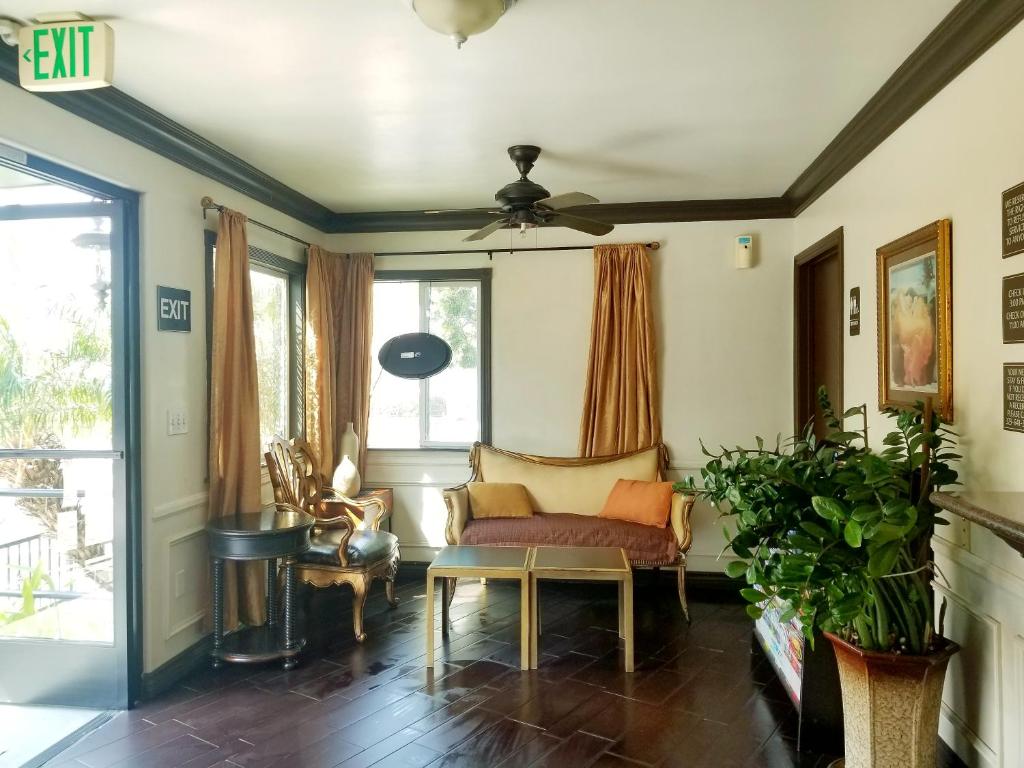 a living room with a couch and a ceiling fan at Casa Bella Inn Downtown LA in Los Angeles
