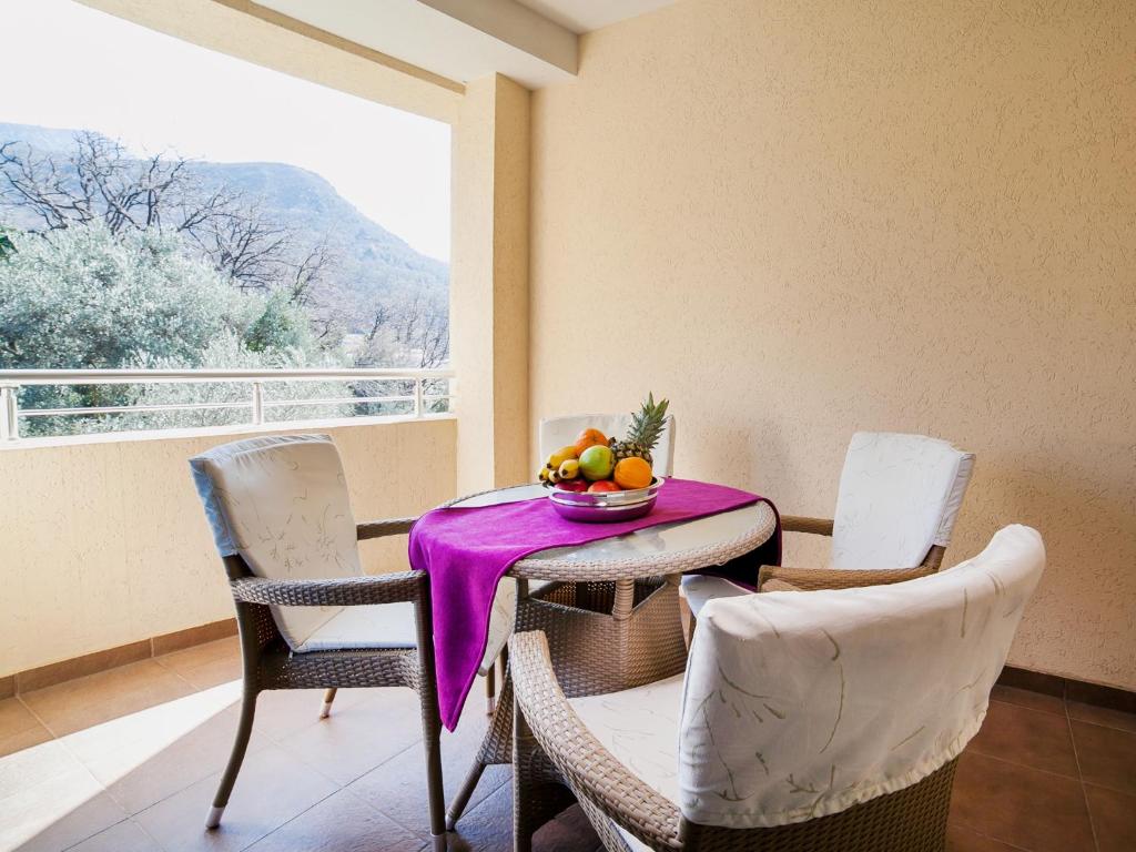 a table and chairs with a bowl of fruit on it at Apartments Raymond in Sveti Stefan