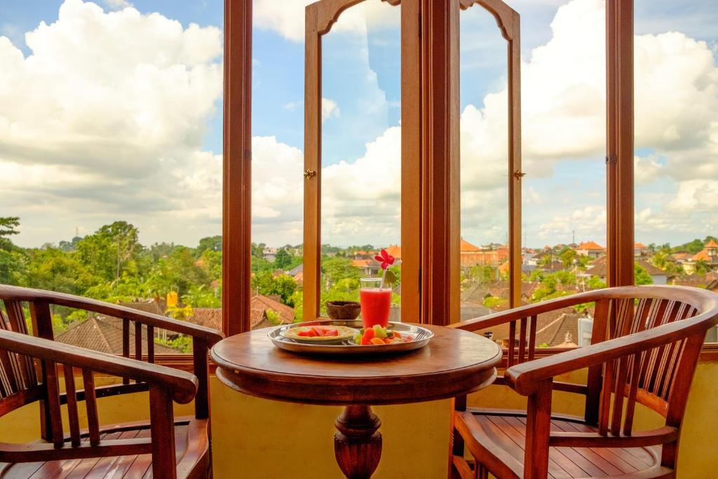 - une table sur un balcon avec un bol de fruits dans l'établissement Bali Spring Cottages, à Ubud