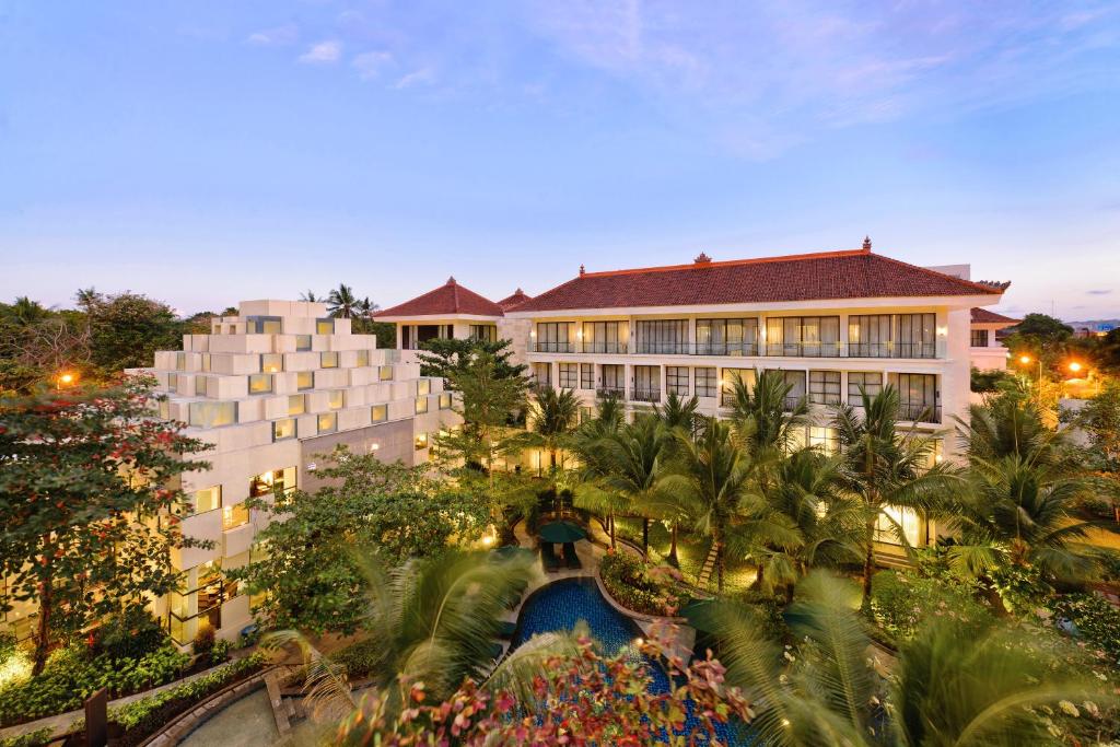 um edifício com piscina em frente a um resort em Bali Nusa Dua Hotel em Nusa Dua